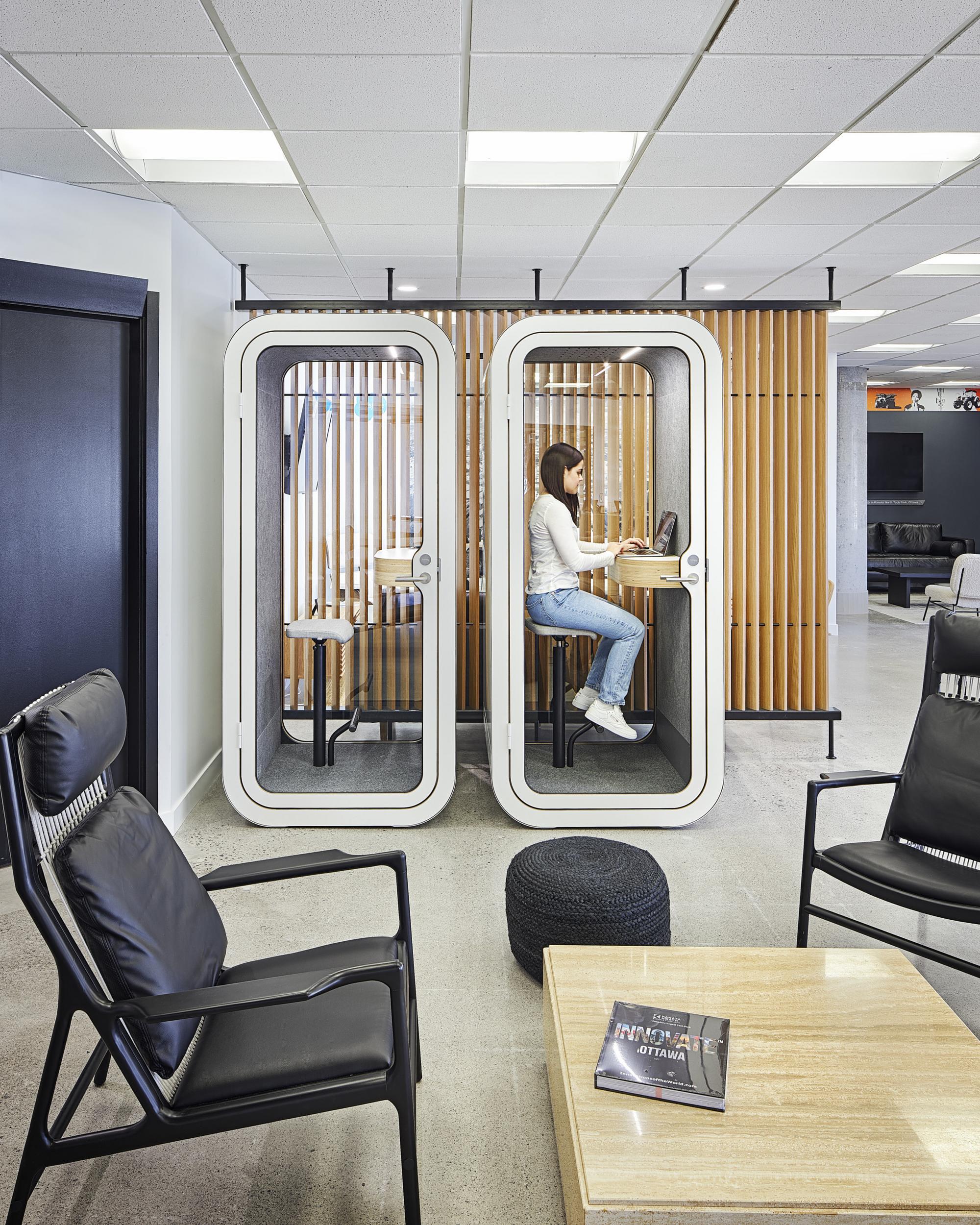 Person working inside a Framery O office pod in Hub350 business center with another Framery O being unoccupied next to it