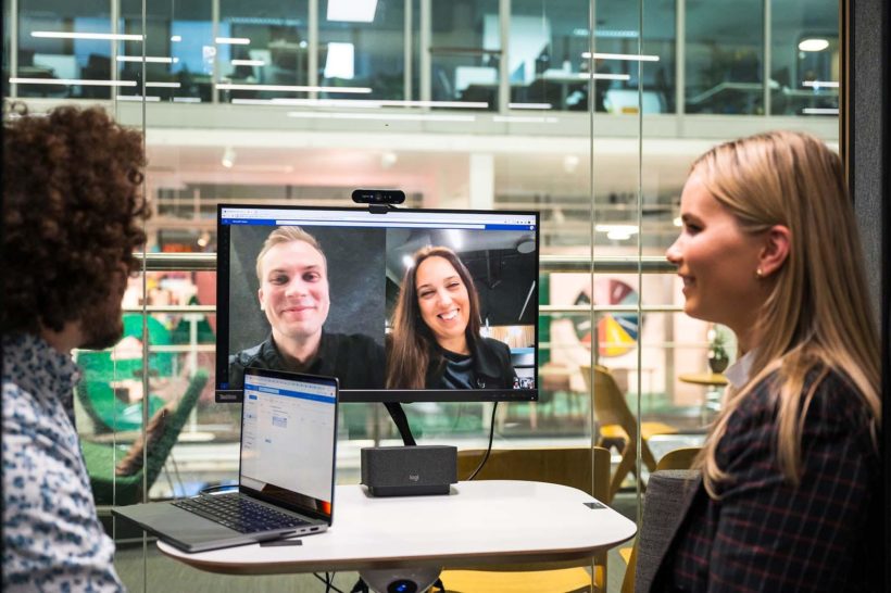 People having a video meeting in a Framery Q pod using Logitech video conferencing setup.