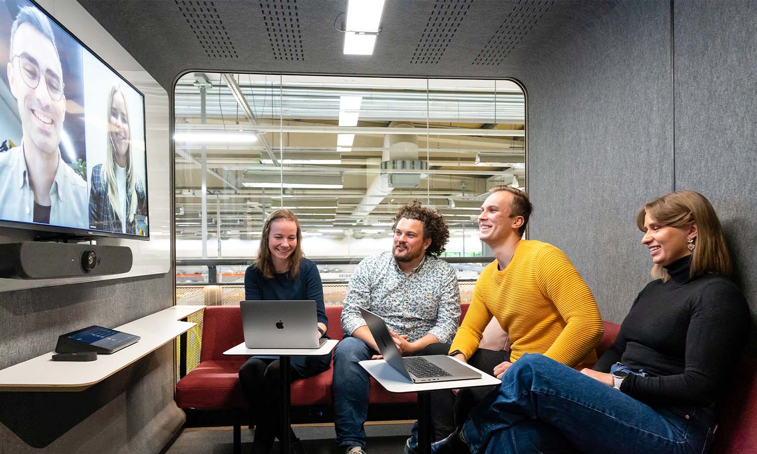 People in video conference inside a Framery 2Q lounge, using a Logitech video conferencing setup.