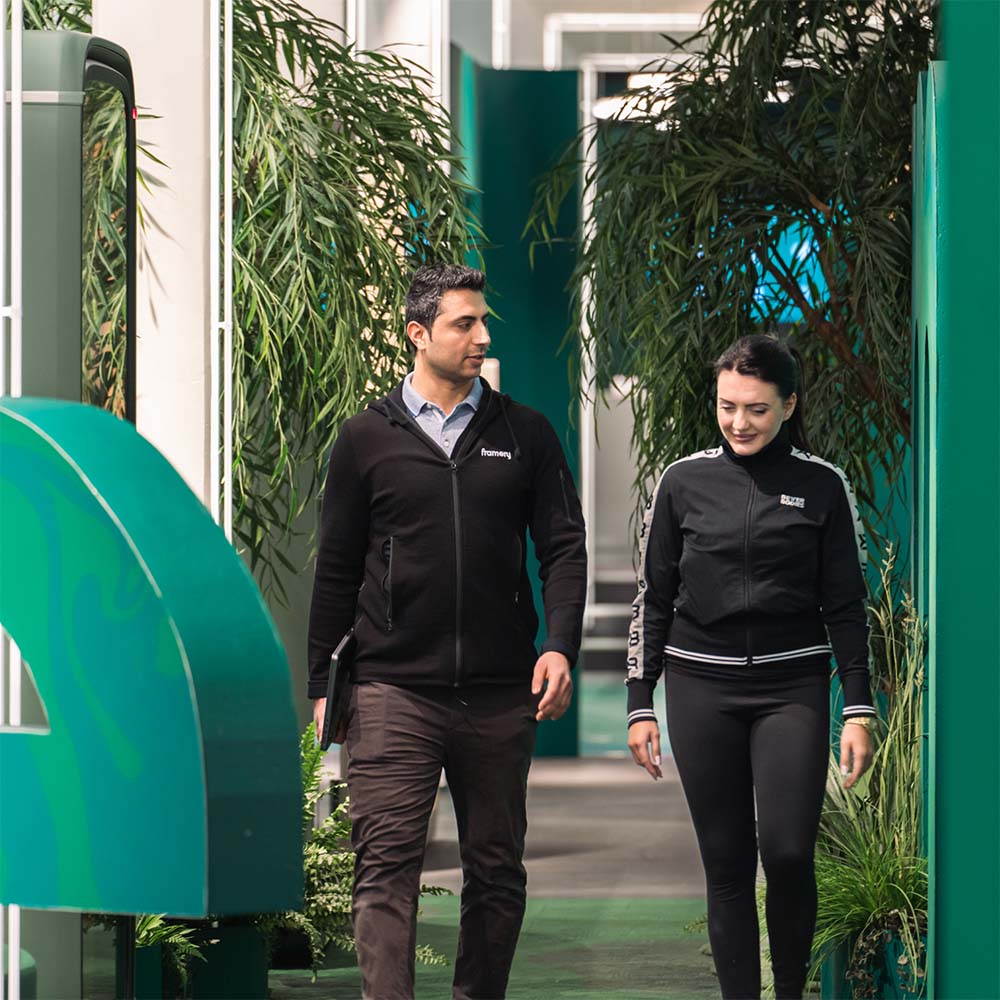 Two people walking a hallway at Framery factory.