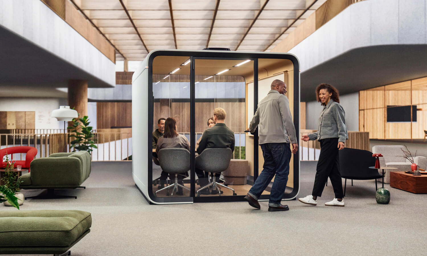 A white colored Framery Six meeting pod in a Scandinavian style office with people in and outside the pod.