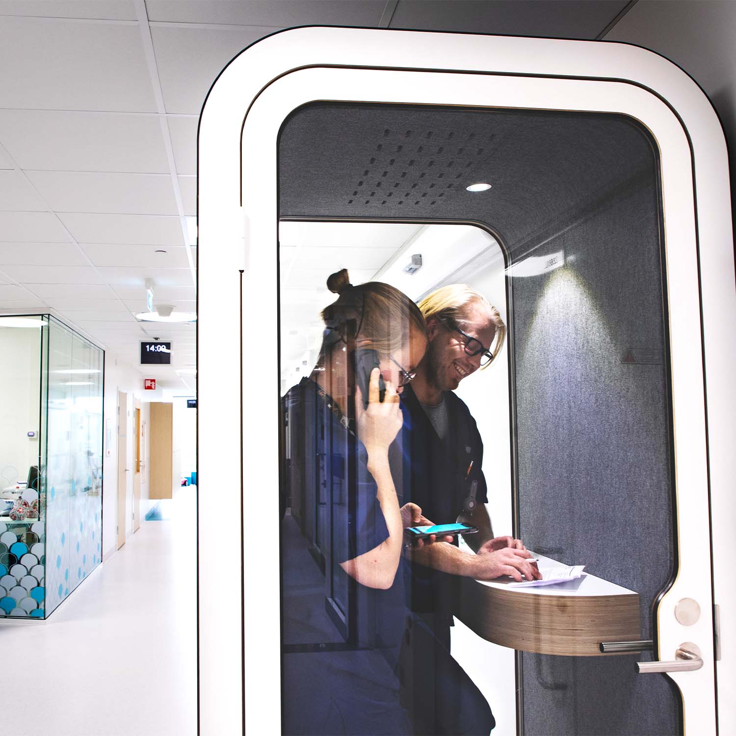 Hospital workers having a private conversation in Framery O office phone booth.