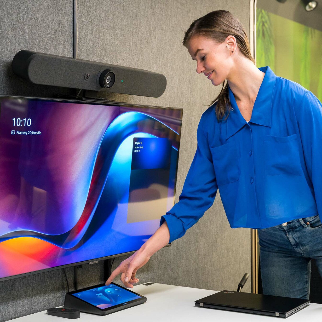 A person joining a meeting inside Framery 2Q meeting room with Logitech Tap.