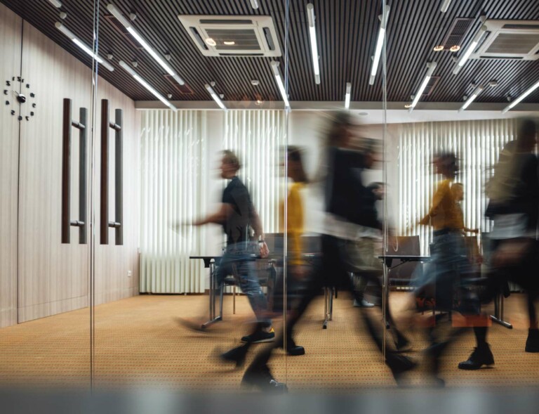 People rushing in the open-plan office.