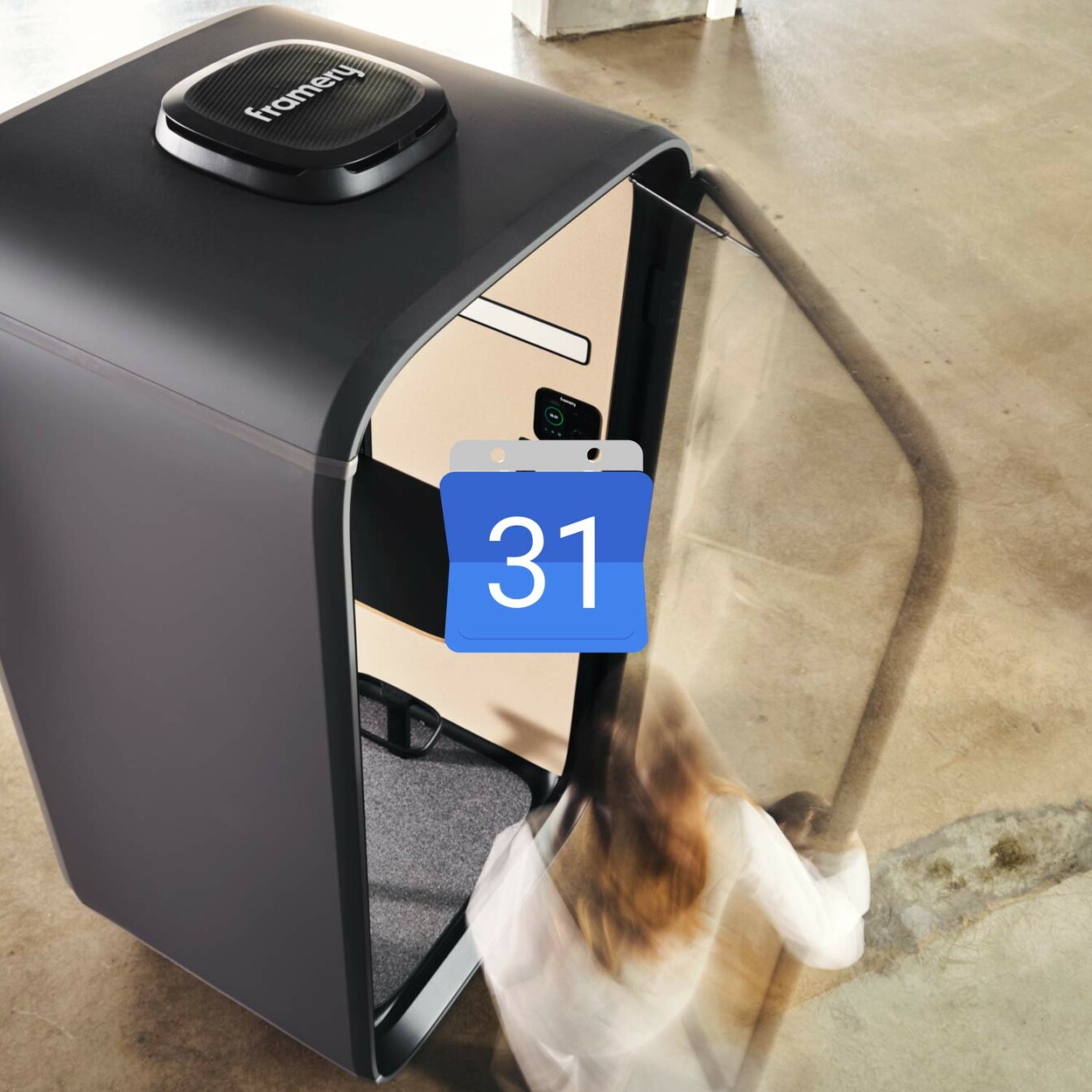 Woman accessing a black Framery One soundproof office pod with a calendar booking