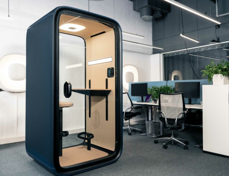 Navy blue Framery One soundproof office pod in an open-plan office.