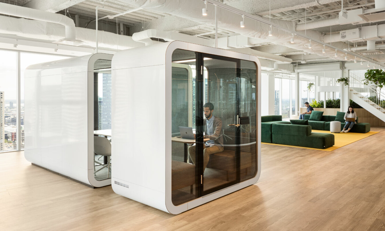 Two white Framery meeting pods in an office.