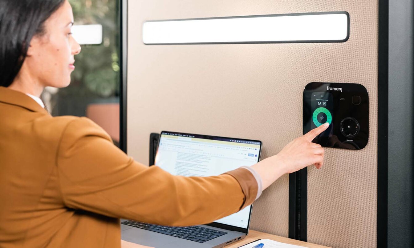 A person using Framery One's touchscreen to extend their meeting within the pod.