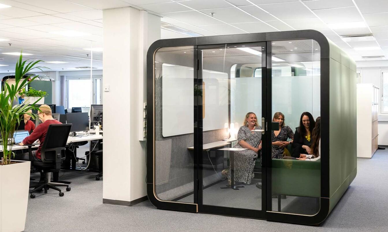 People having an ad hoc meeting inside a Framery 2Q meeting room.