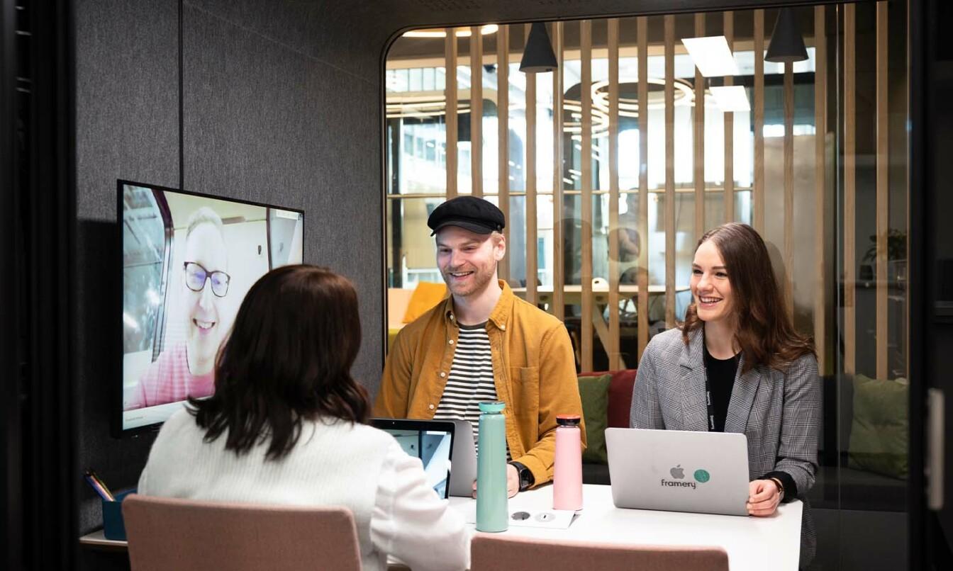 People having a hybrid meeting inside a Framery 2Q meeting room.