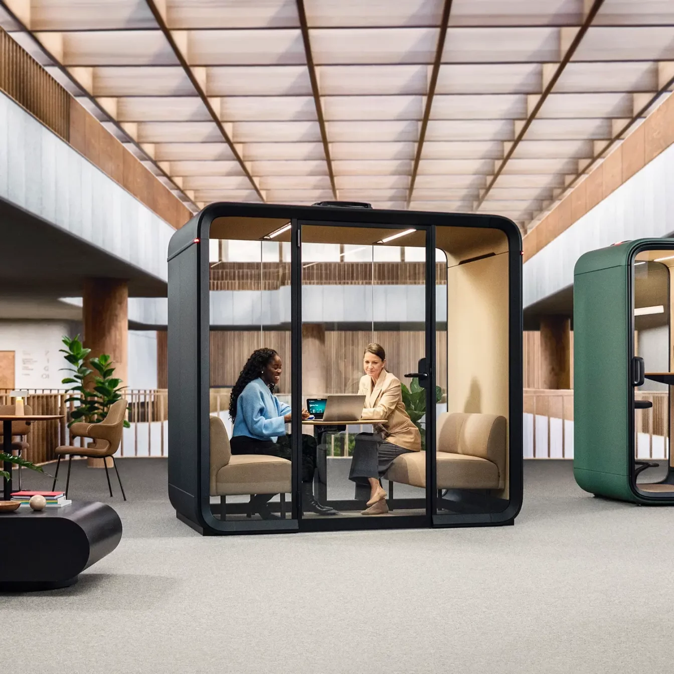 People having a meeting inside a Framery Four smart meeting pod.