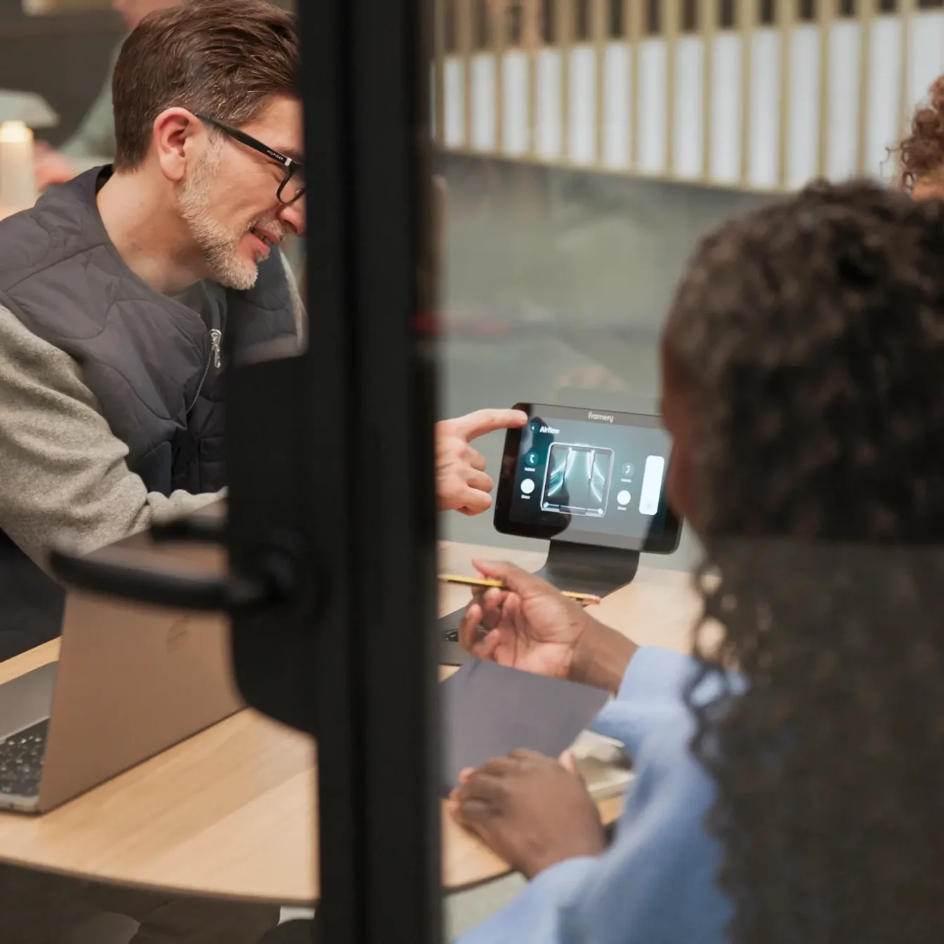 A person adjusting the meeting pod's settings with Framery Four's touchscreen.