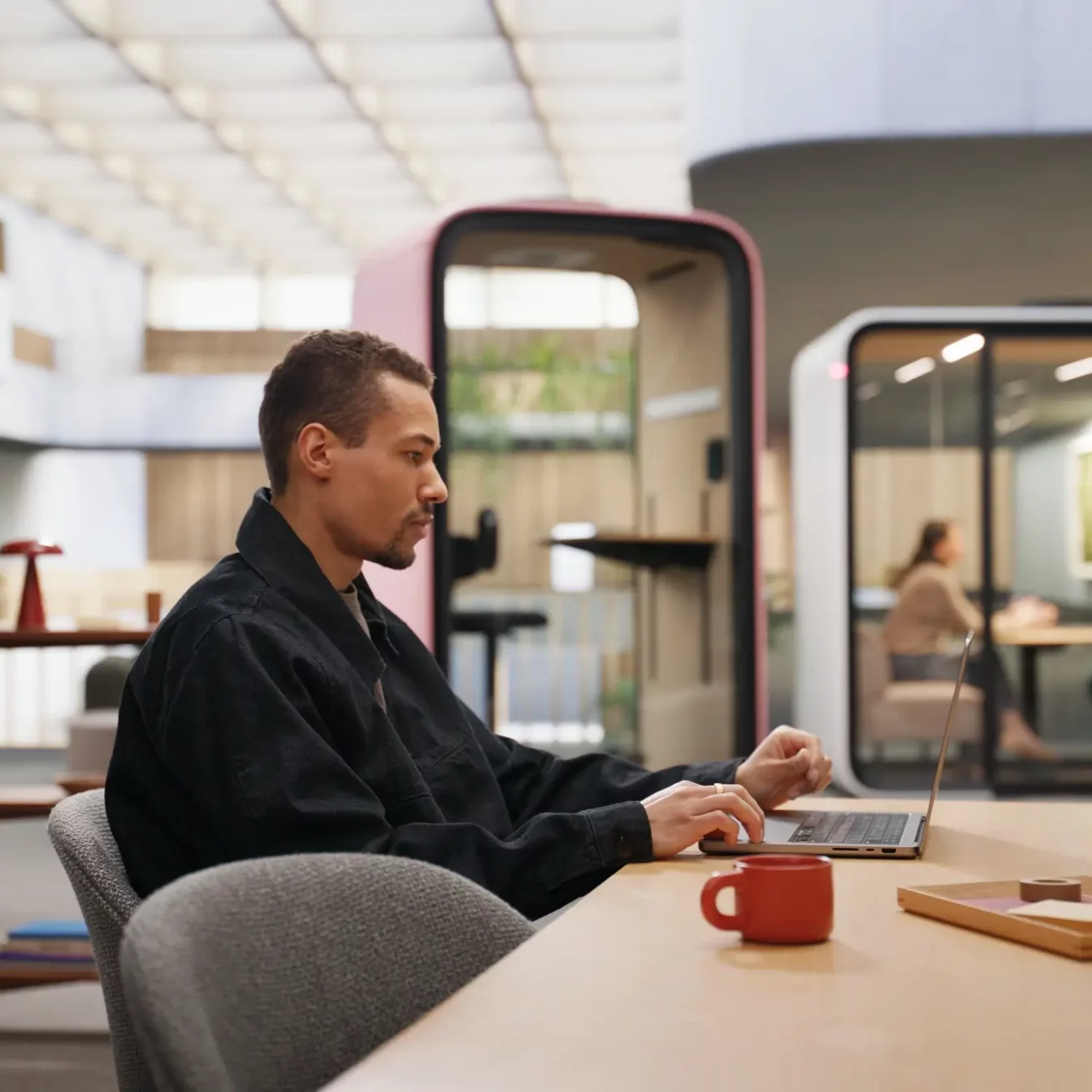 A person working next to Framery office pods