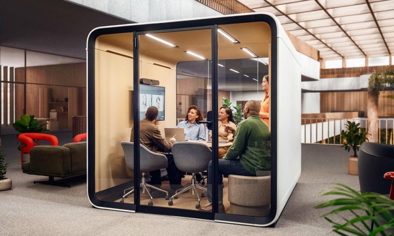 A five person team having a video conference in a Framery Six meeting room.