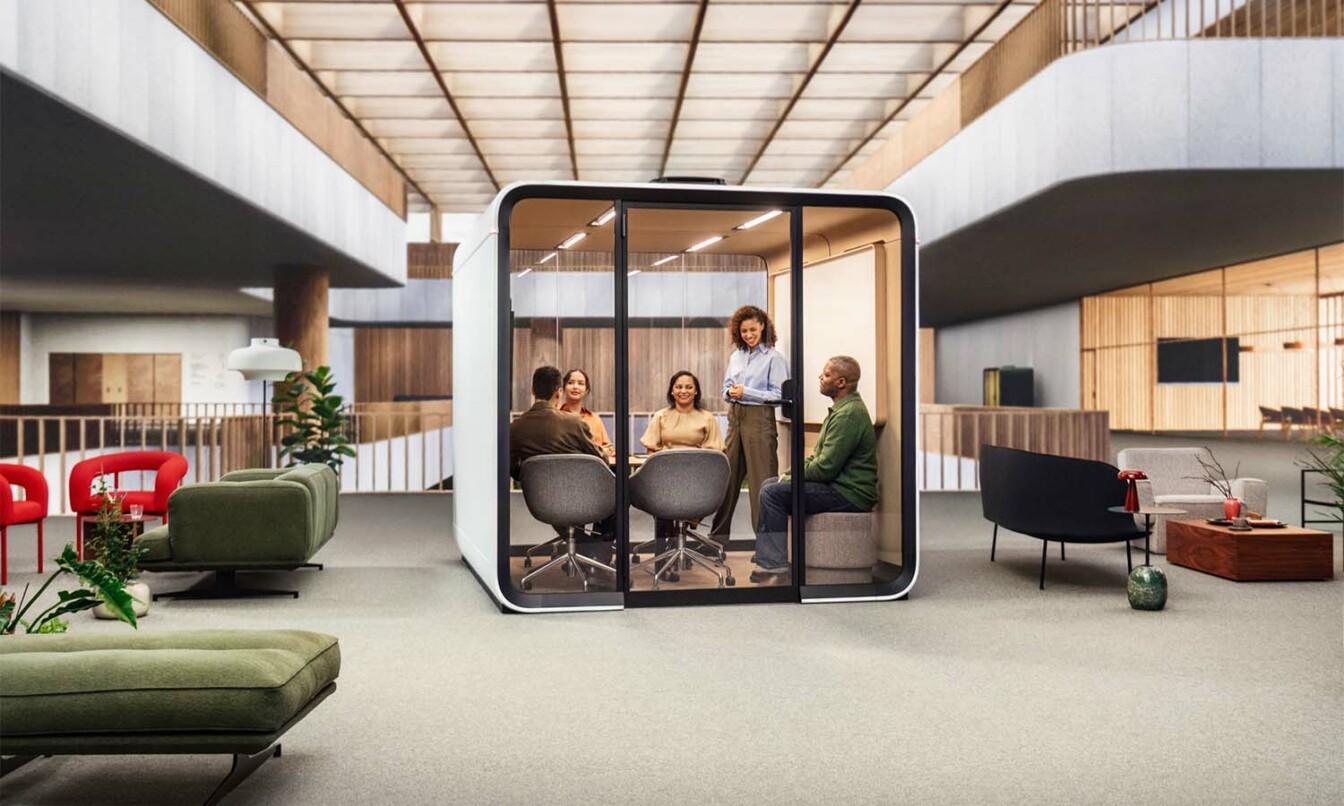 People having an in-person meeting in a Framery Six meeting pod.