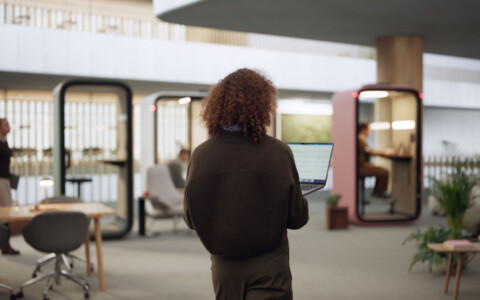 A person walking towards a Framery smart pod.