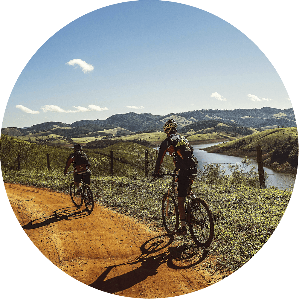 Two people bicycling in a valley scenery.