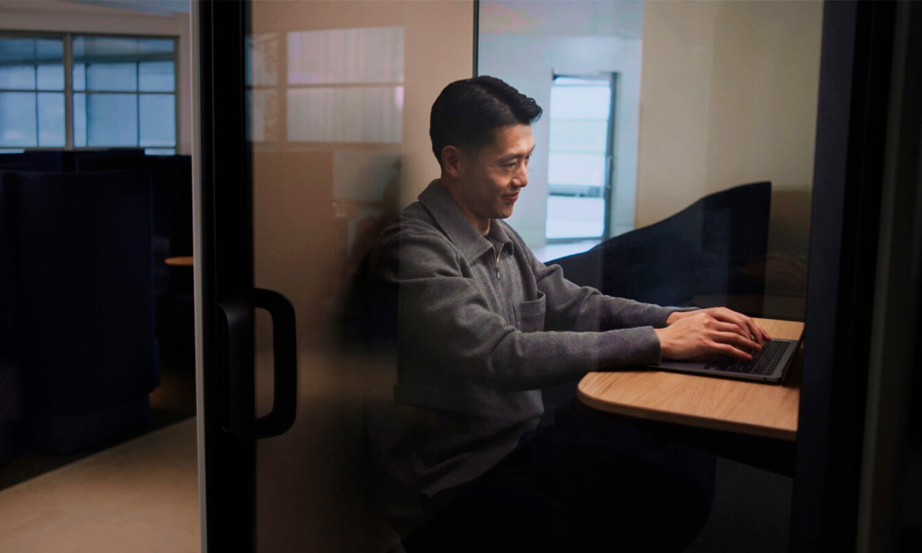 Closeup of a man sitting inside a Framery One phone booth at Finnair Schengen lounge.