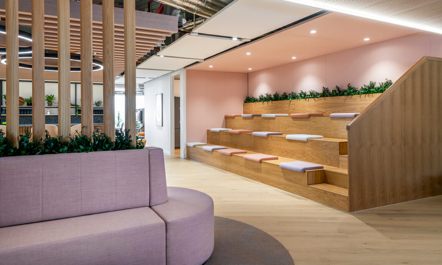 Light wooden and pastel coloured seating in an office.