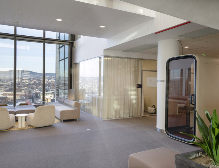 A light colored office lobby with big window and light color furniture