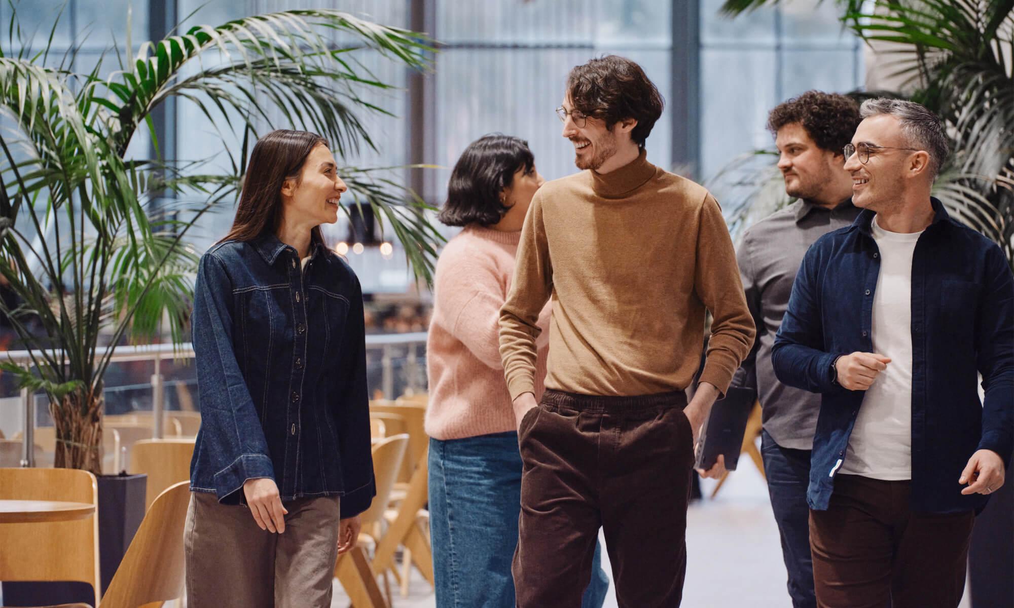 Group of happy looking people walking up a corridor.