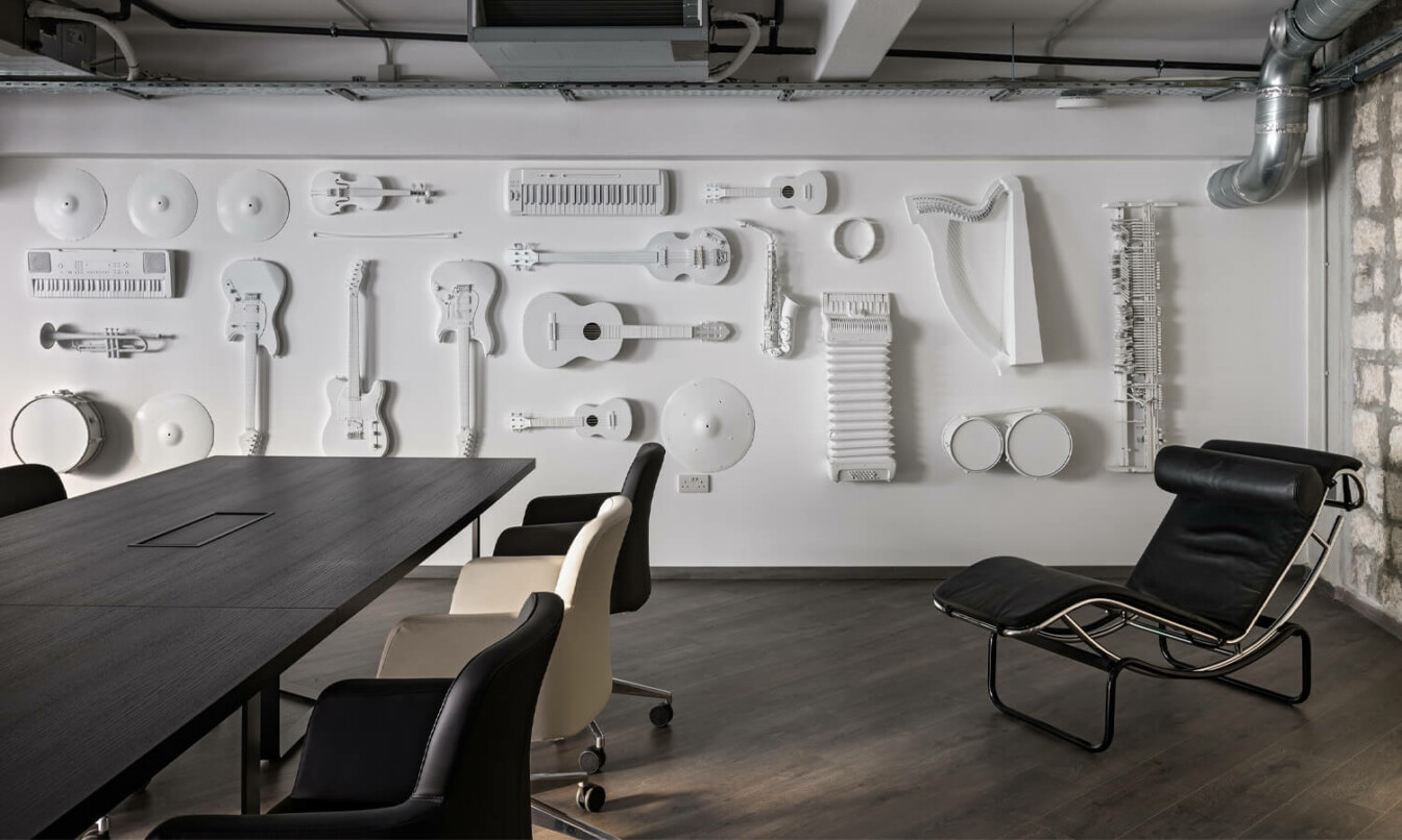 Office meeting room with white painted instruments handing on white back wall.