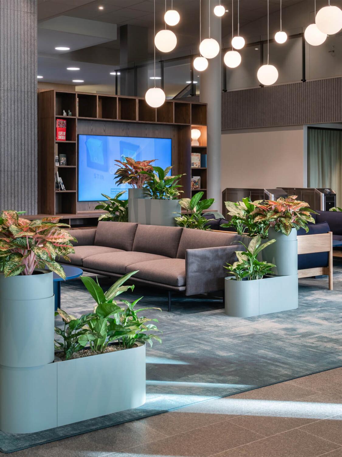 A blue-toned and stylish office lobby with round pendants hanging from ceiling.