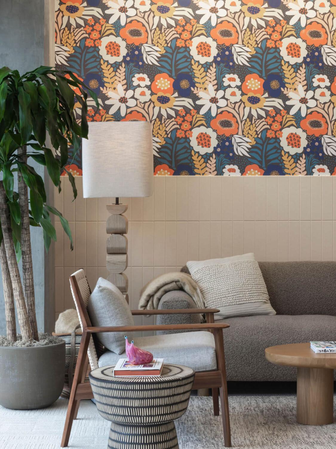 An office lounge corner with flower wallpaper and cozy seating.