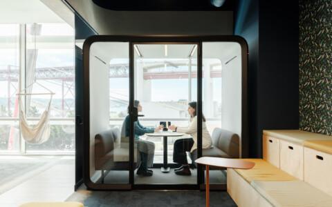 Office pod in front of a window with 2 persons inside