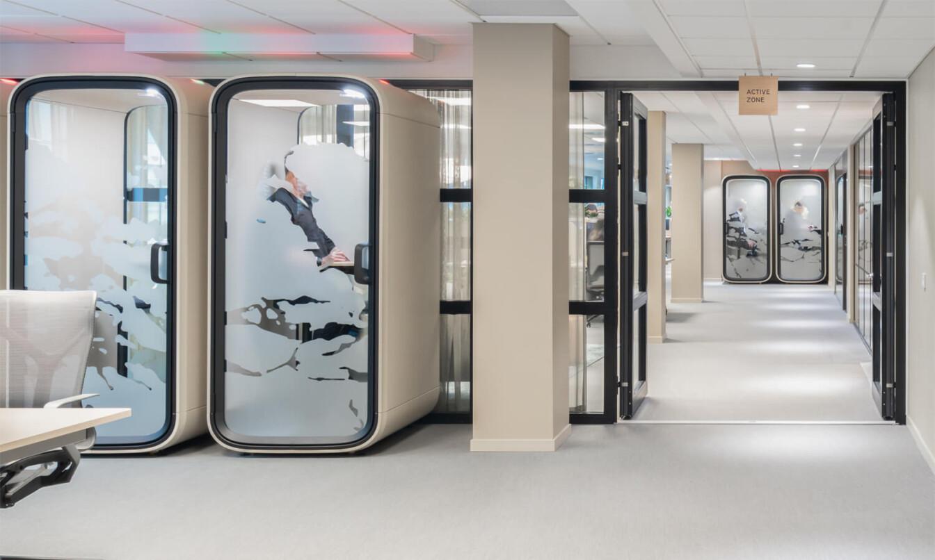 A light toned office with two light toned Framery One pods.