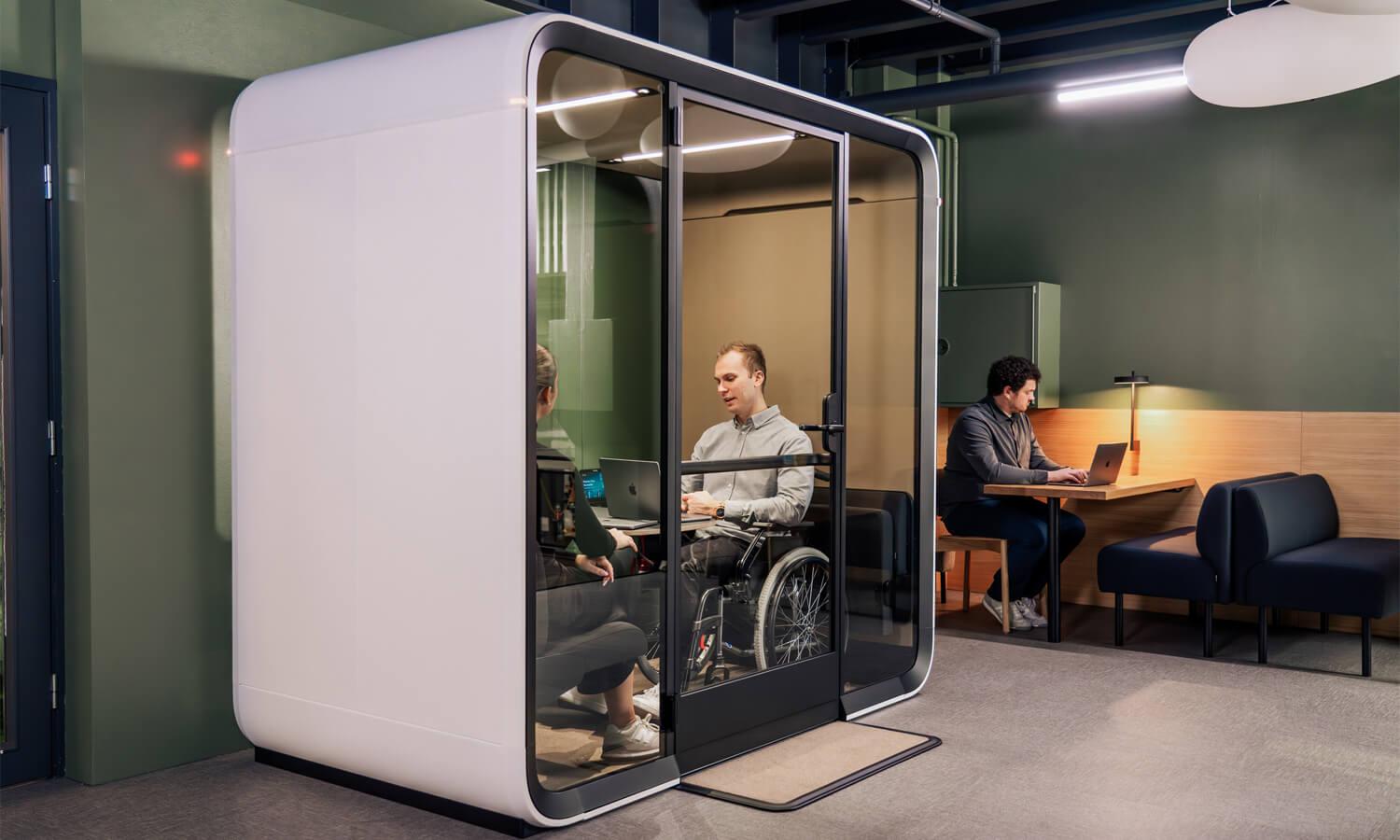 An accessible pod with people inside, in an office.