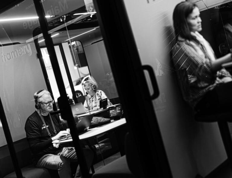 Black and white tilted image of people working inside smart pods.