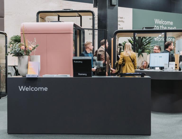 A fair stand with a black counter and smart pods behind it.