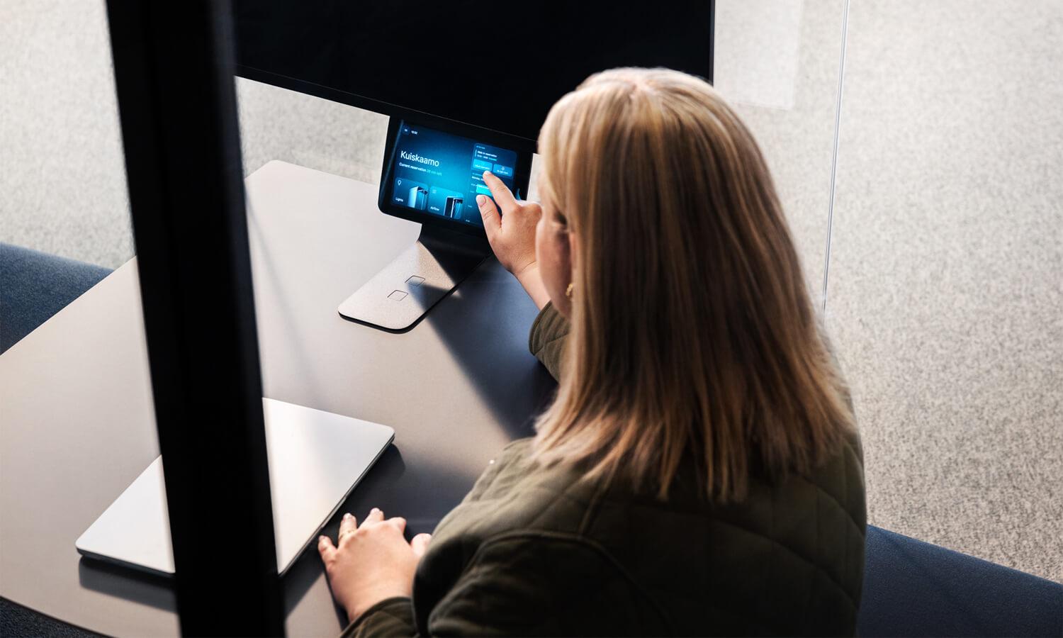 A woman reserving a Framery smart pod thgought the pod's touchscreen.