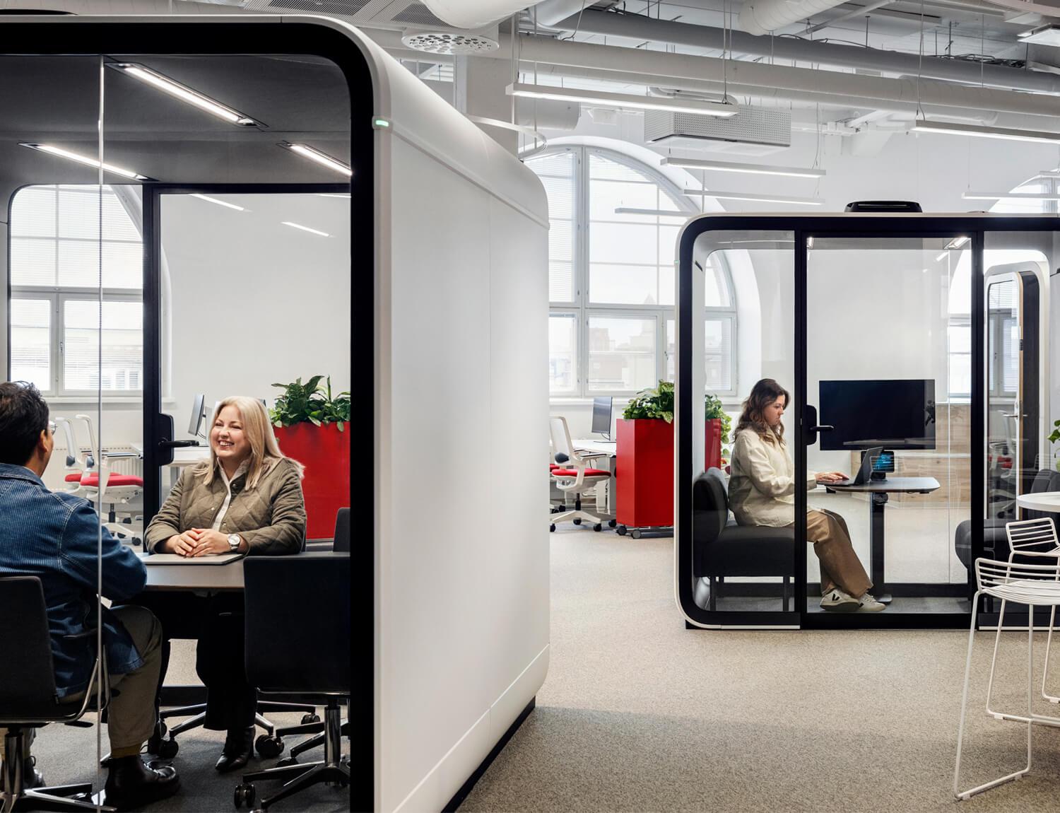 Framery Four and Six meeting pods in an office with people working inside of the pods.