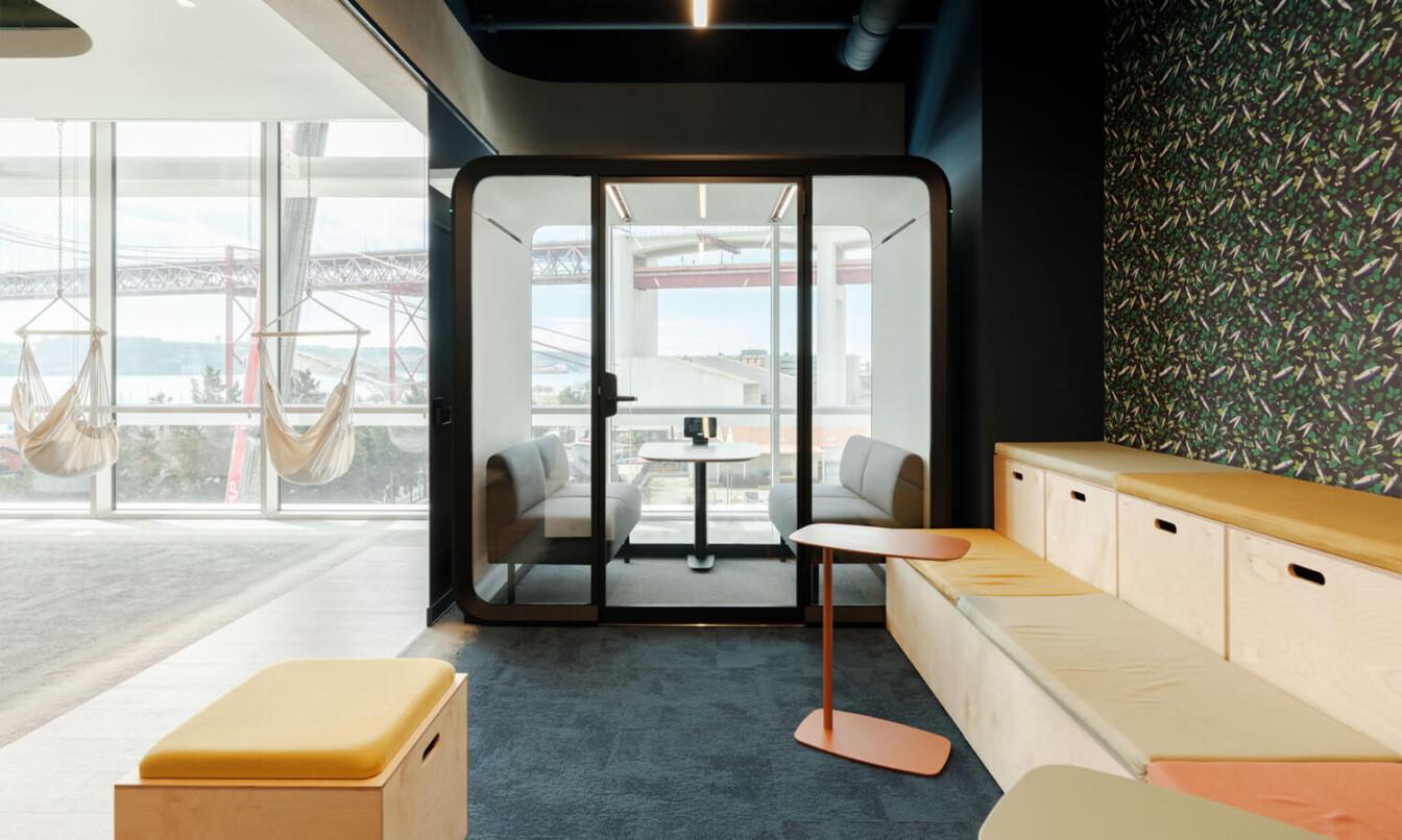 A Framery Four meeting pod in an office, next to a window.