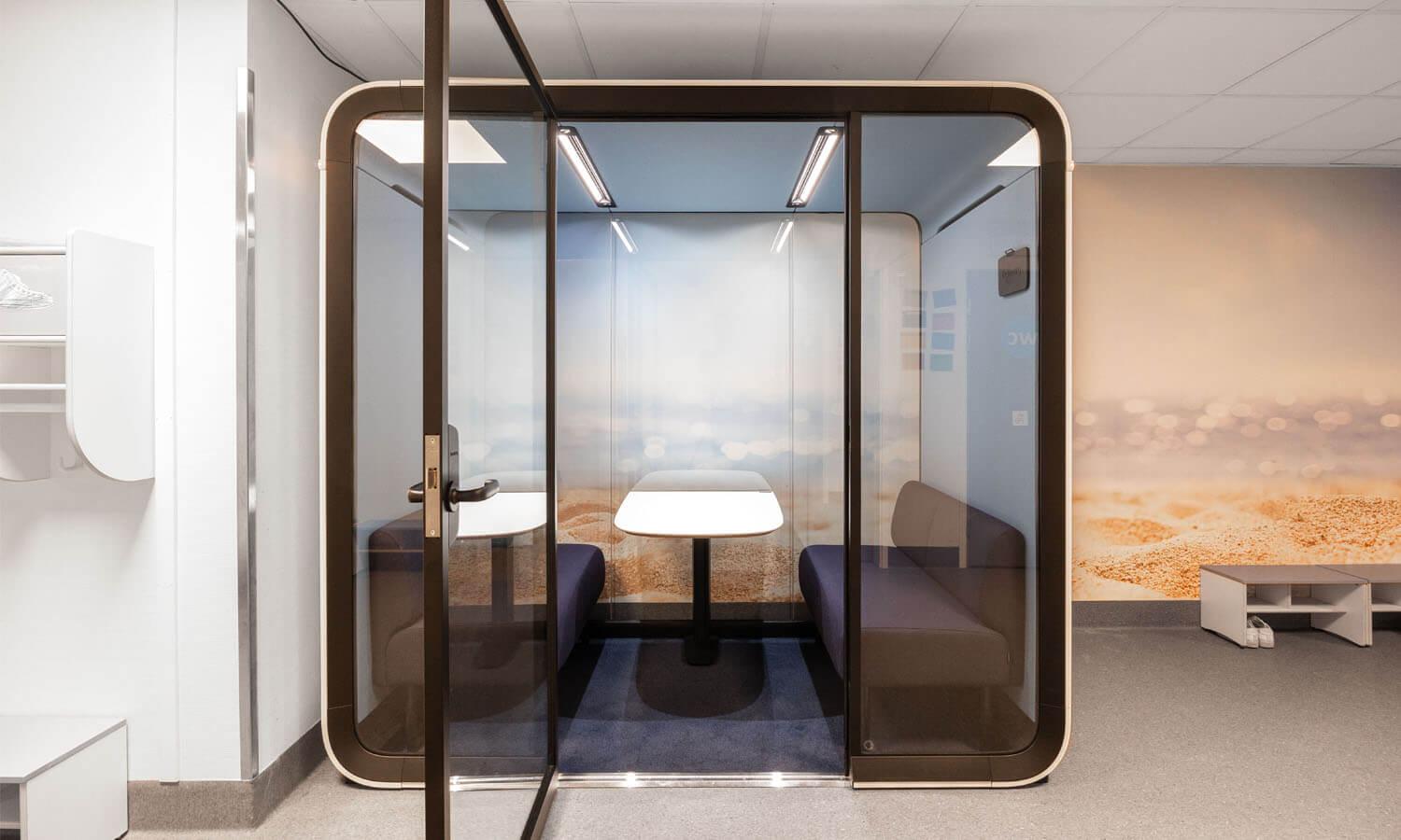 A neutral toned Framery Four study pod with its door open in a school hallway.