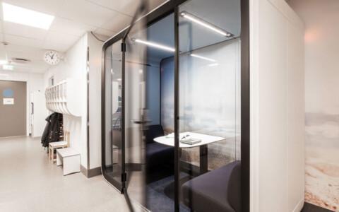 A white Framery Four study pod in a school corridor.