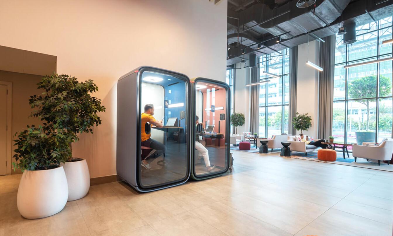 Two Framery smart pods in a spacious hotel lobby.