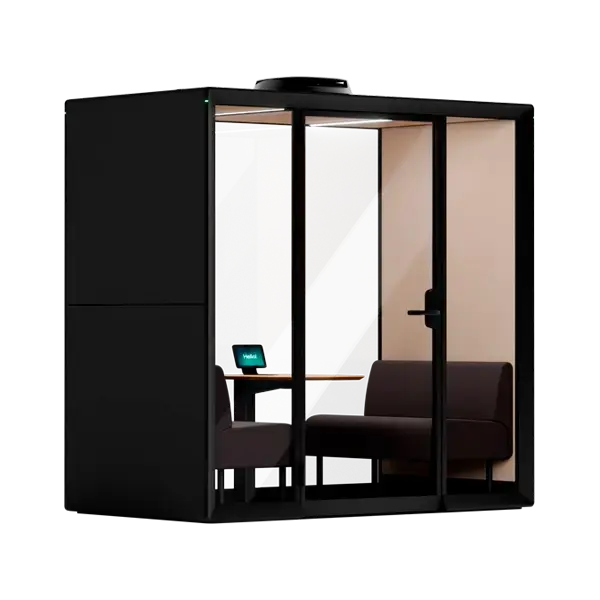 A modern black glass-walled office pod with a small desk, laptop, and seating inside.