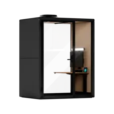 Black metal cabinet with a glass door, revealing a small wooden office inside with a desk and laptop.