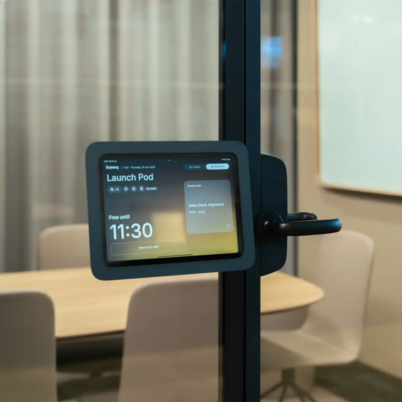 A wall-mounted tablet on a glass door frame showing a "Launch Pod" screen and the time 11:30.