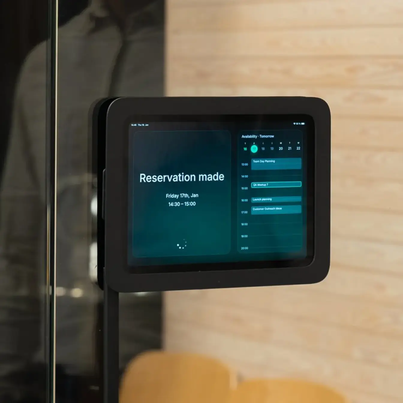 Wall-mounted tablet displaying a "Reservation made" confirmation with a schedule on the right.
