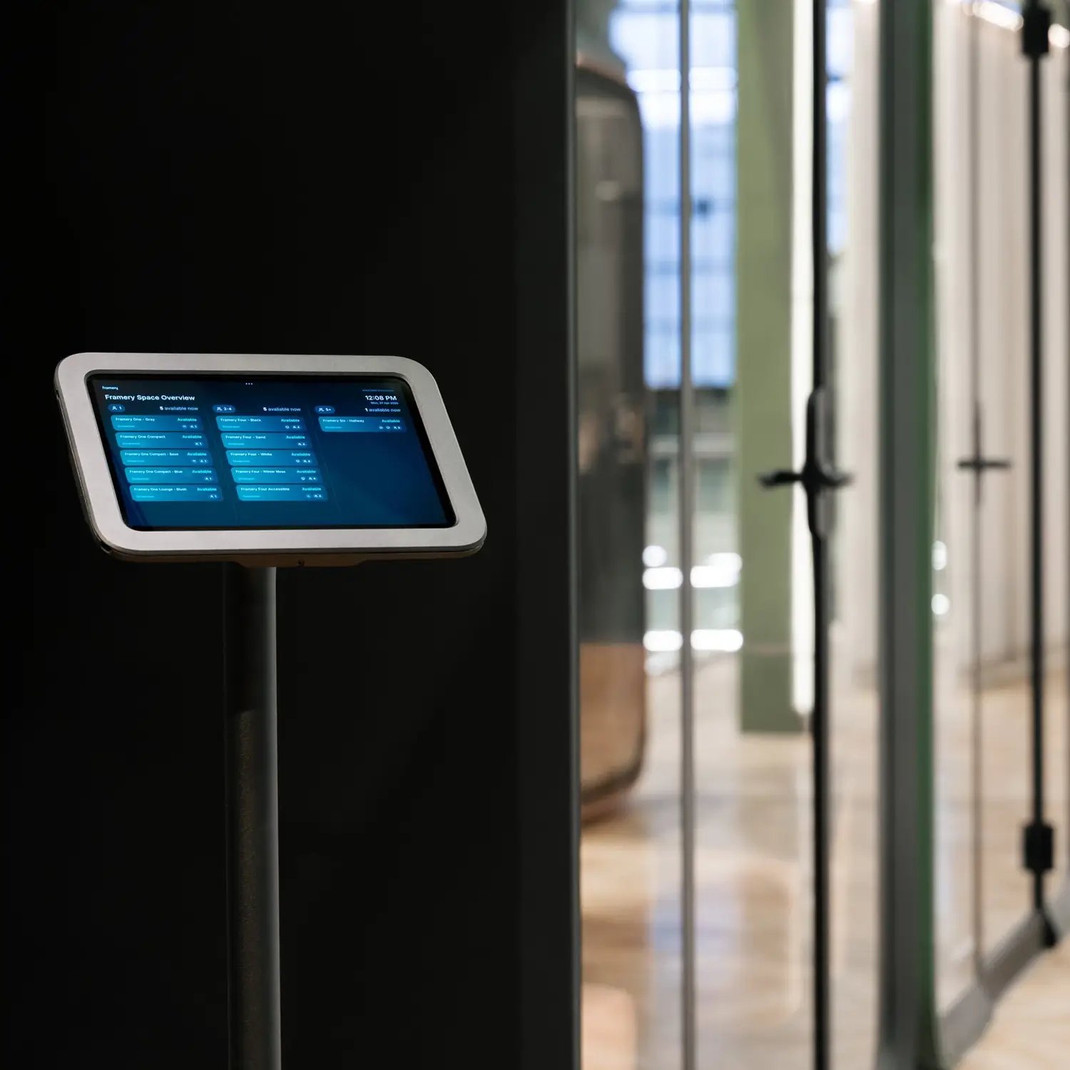 Touchscreen information kiosk on a stand inside a modern building.
