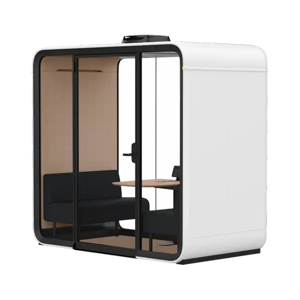 White modular glass-walled meeting pod with a black sofa and a small wooden table inside.