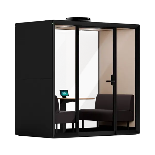 A Framery Gradus Huddle smart and soundproof huddle room with a desk, chair, laptop, and sofa inside.