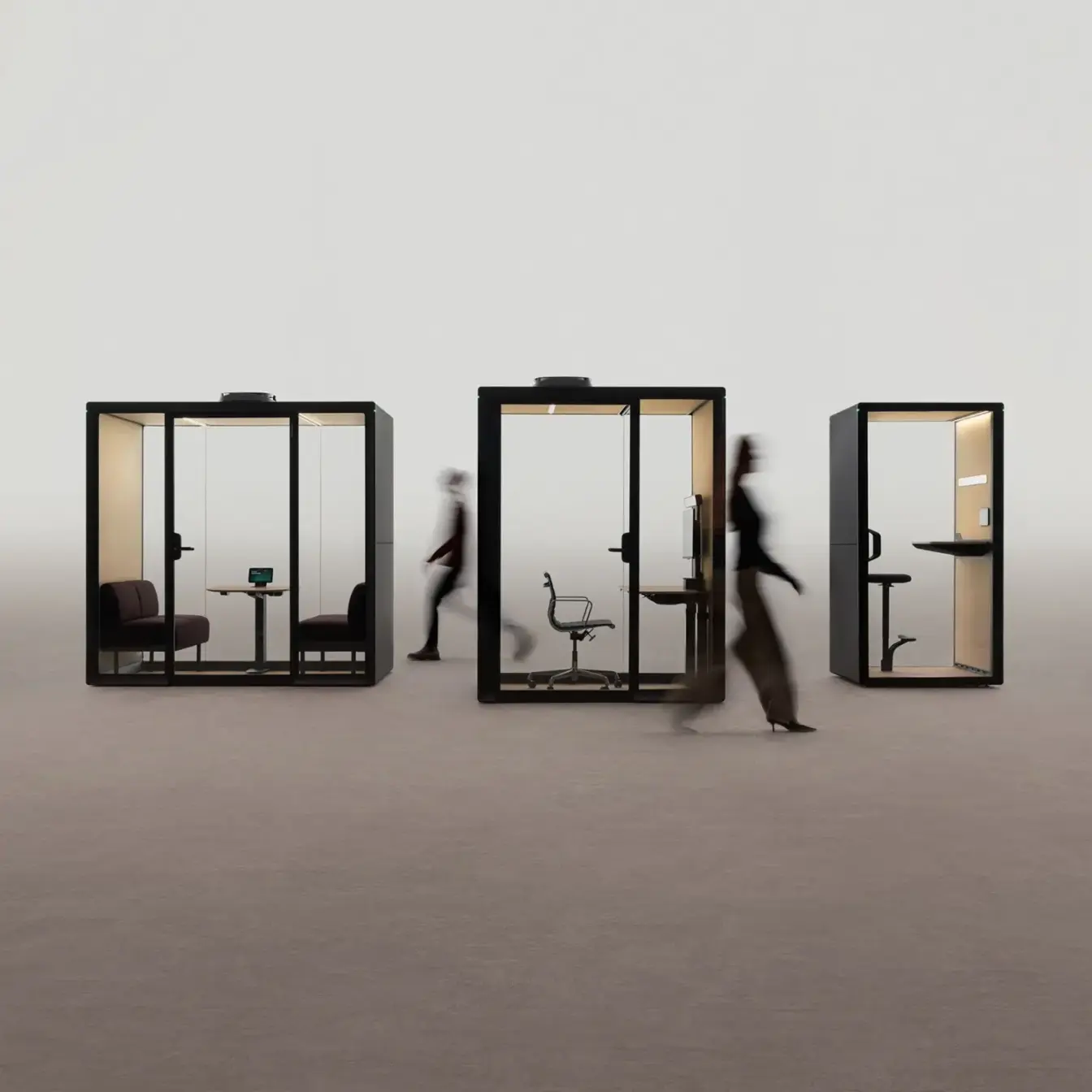 Three glass-walled Framery Gradus smart and soundproof office pods on an empty landscape with blurred figures walking by.