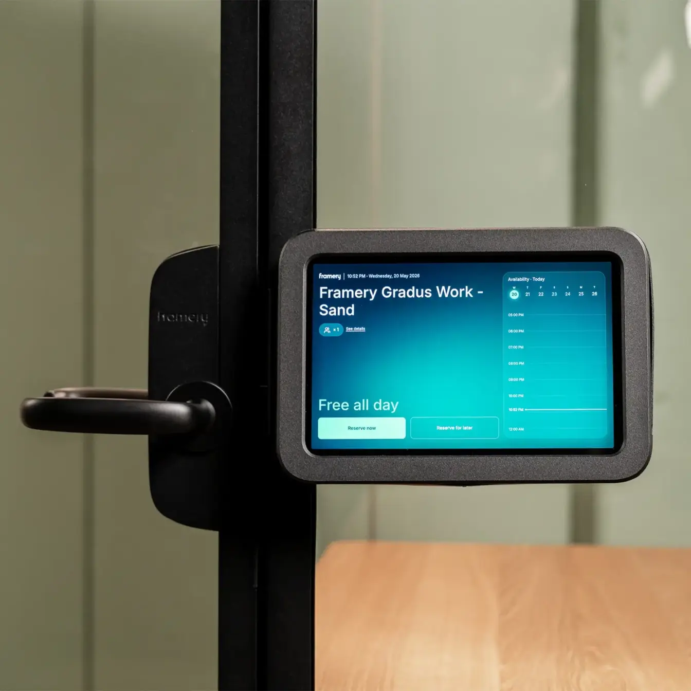 Touchscreen panel mounted on a glass door frame displaying a blue interface.