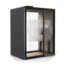 A compact black soundproof office booth with glass doors and a light wooden floor.