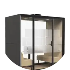 Glass-walled private meeting pod with two beige chairs and a small table.